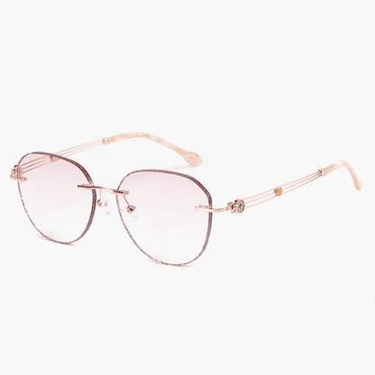 PR016 rimless glitter-powder-studded eyeglasses are crafted from elegant metal, making them incredibly lightweight and comfortable. They feature slender temple arms and gradient light pink tinted lenses, ideal for women during the summer.