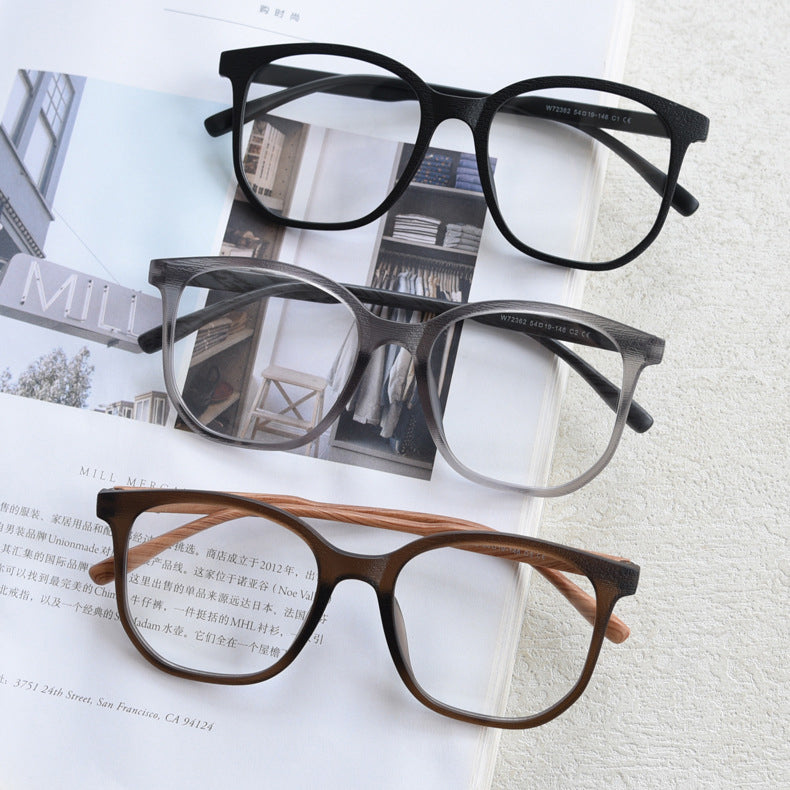 MieMie affordable TR90 wood-textured oversized eyeglass frames in multiple colors, including Brown, Coffee, Green, Grey, Tortoise, and Matte Black. Features ALL-IN-ONE lenses with multi-coating benefits like Anti-blue, Anti-scratch, Anti-glare, Anti-allergic, and Oil-resistant, offering a stylish and face-slimming look.