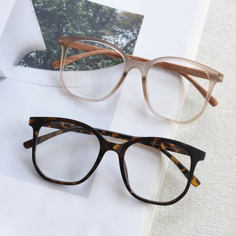 MieMie affordable TR90 wood-textured oversized eyeglass frames in multiple colors, including Brown, Coffee, Green, Grey, Tortoise, and Matte Black. Features ALL-IN-ONE lenses with multi-coating benefits like Anti-blue, Anti-scratch, Anti-glare, Anti-allergic, and Oil-resistant, offering a stylish and face-slimming look.