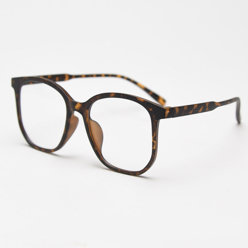 MieMie affordable TR90 wood-textured oversized eyeglass frames in multiple colors, including Brown, Coffee, Green, Grey, Tortoise, and Matte Black. Features ALL-IN-ONE lenses with multi-coating benefits like Anti-blue, Anti-scratch, Anti-glare, Anti-allergic, and Oil-resistant, offering a stylish and face-slimming look.